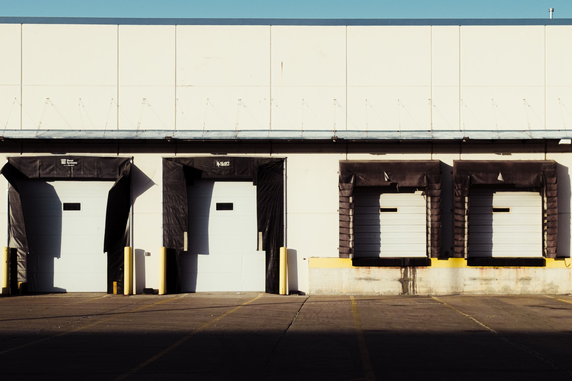 Exterior of an industrial building with a row of truck loading dock doors