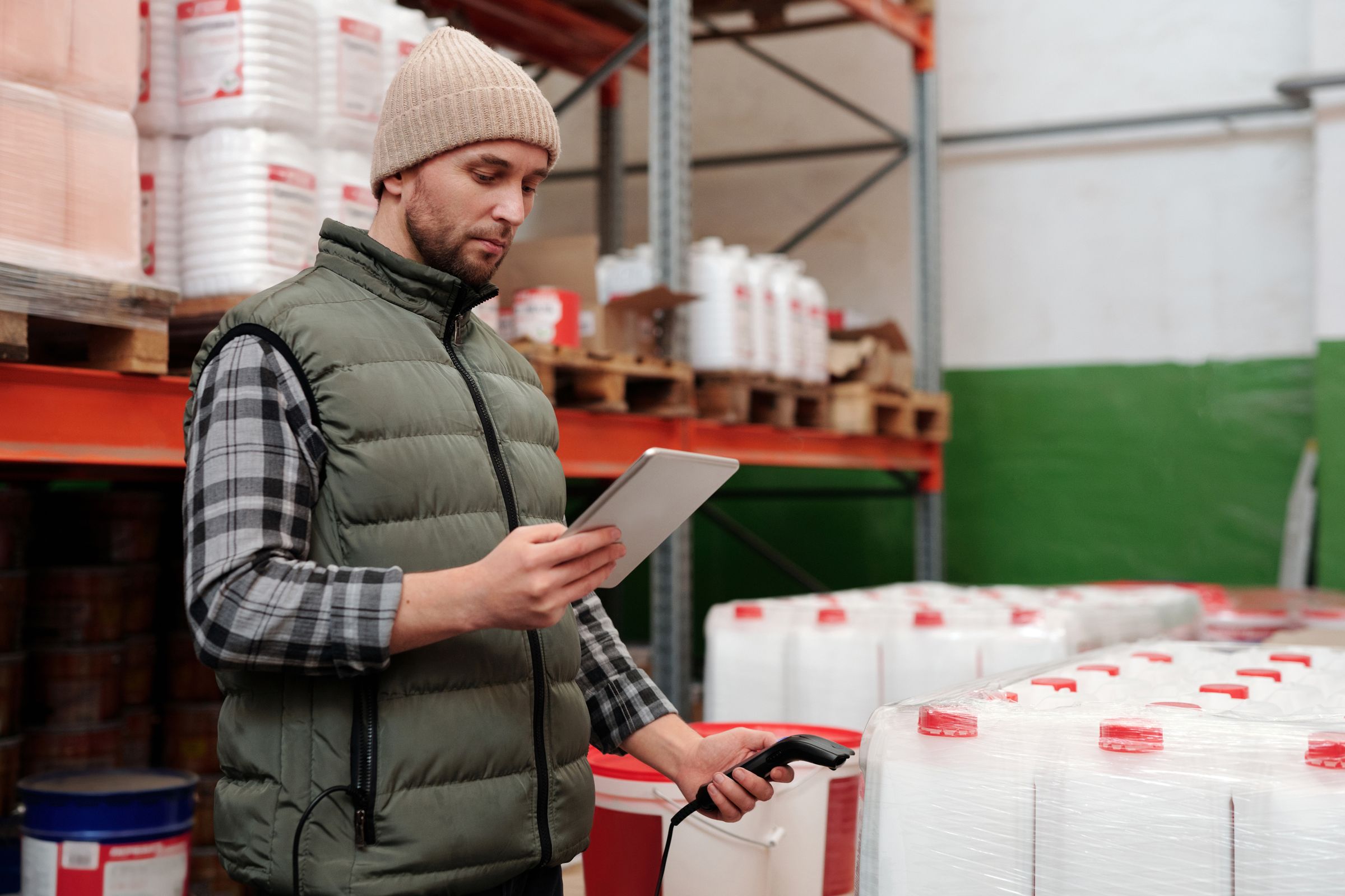 Warehouse associate checking inventory on shelving with a clipboard