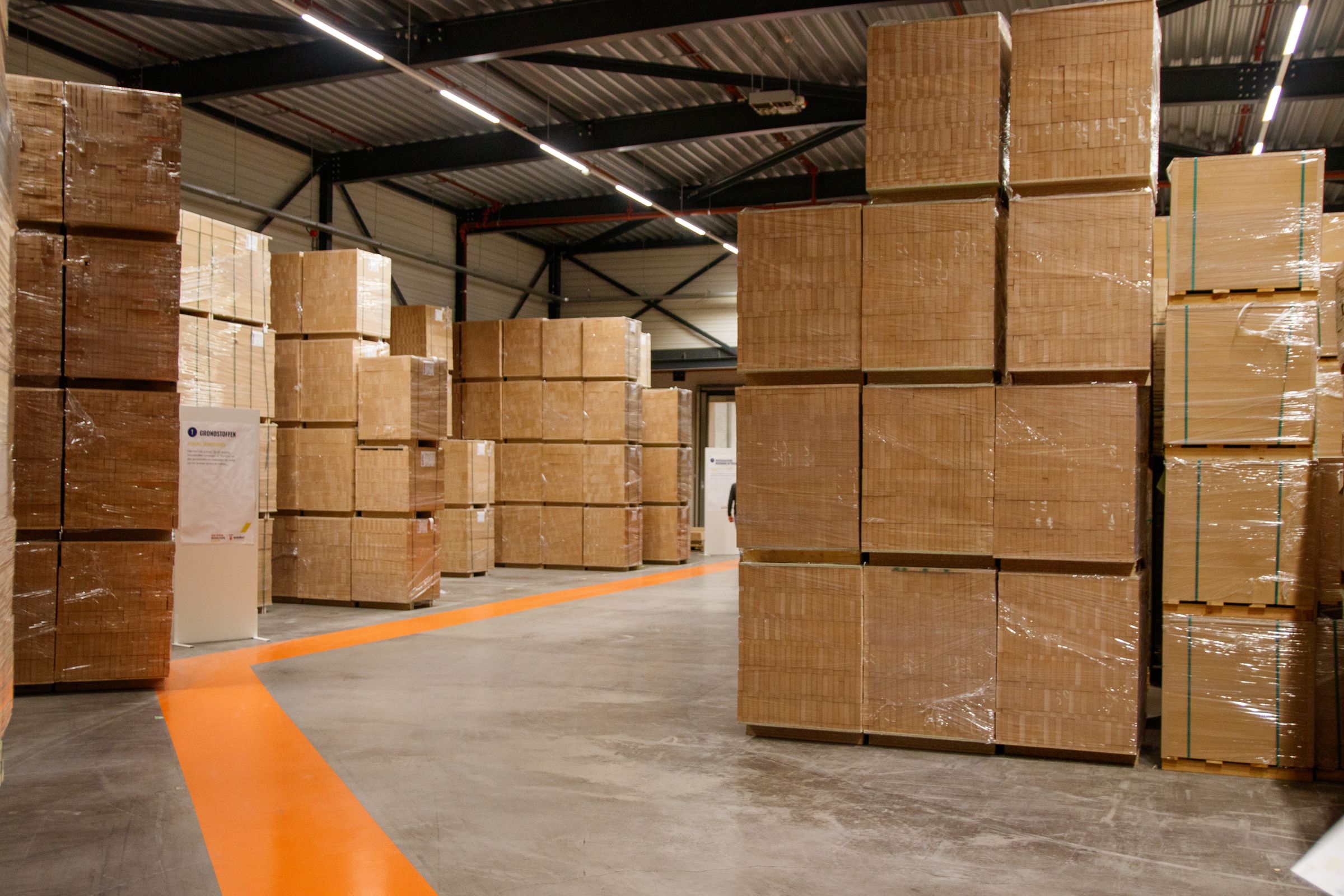 Cartons stacked on pallets inside a warehouse, staged for shipment